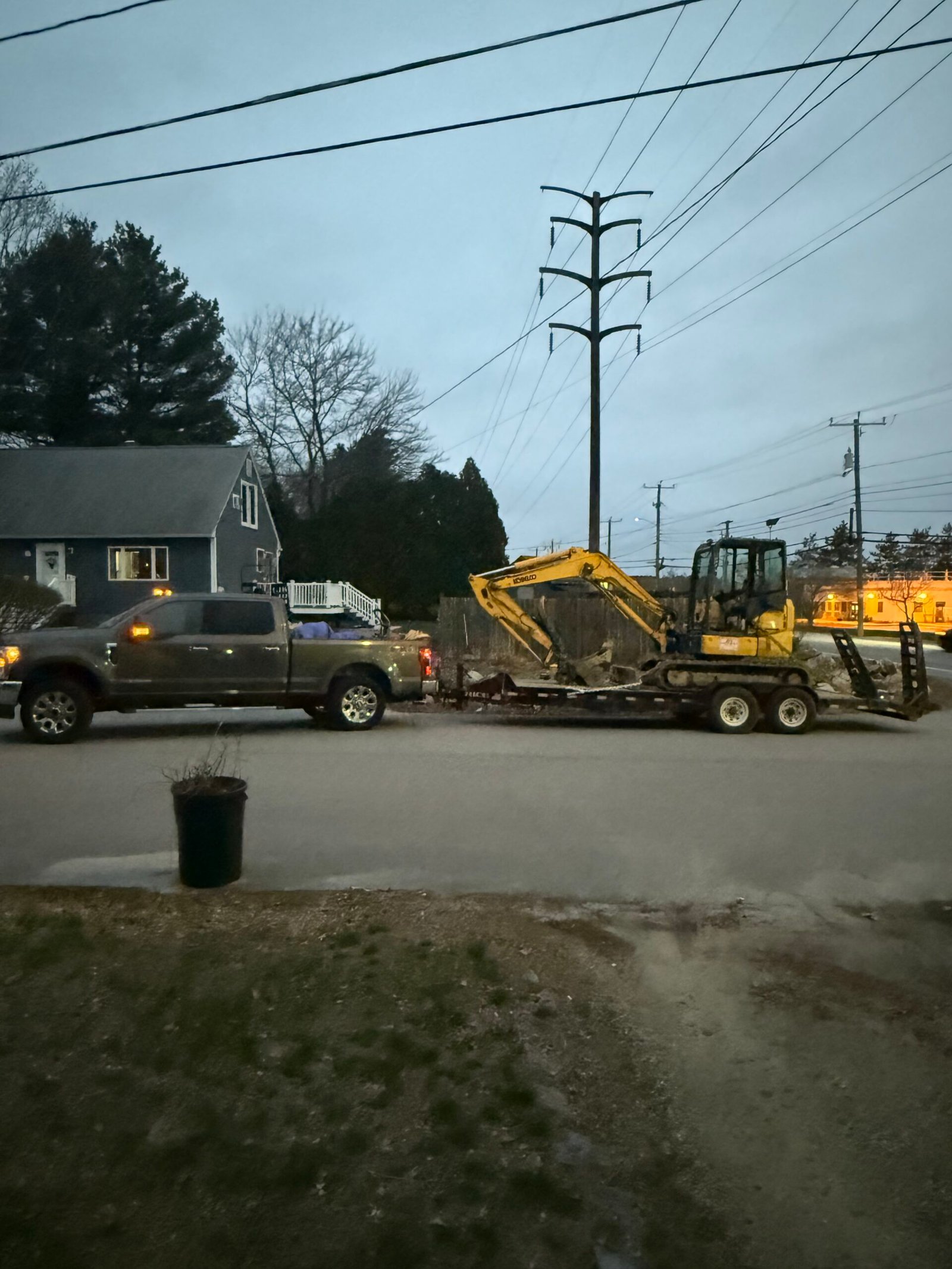 Compact excavator loaded on a trailer for transport