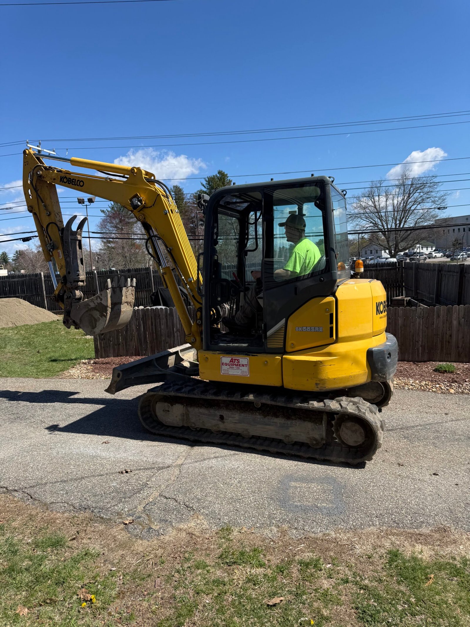 Compact excavator working on a residential hardscape project