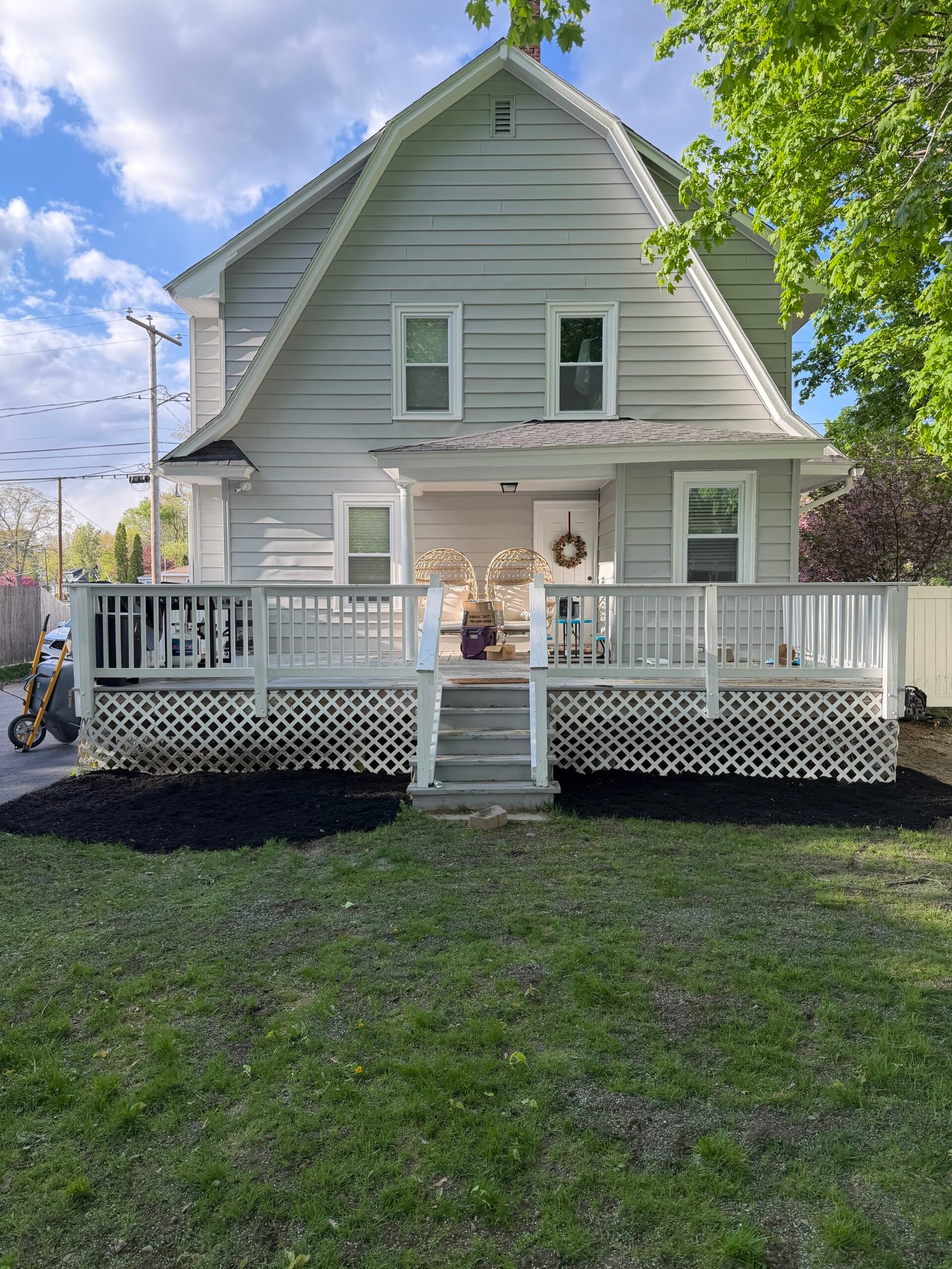 Fresh mulch bed along a white front porch and walkway
